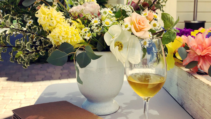 Flowers in a vase with a glass of wine